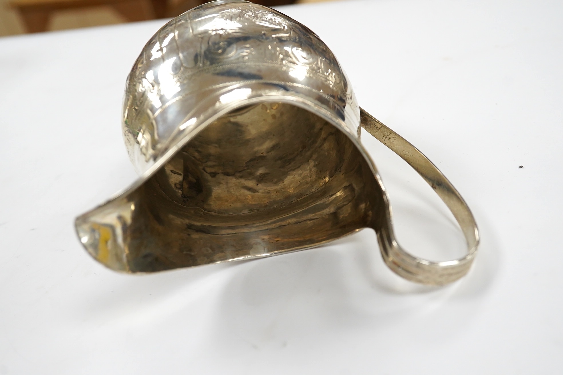 A George III engraved silver helmet shaped cream jug, London, 1801, 12.4cm, 3.4oz. Condition - poor